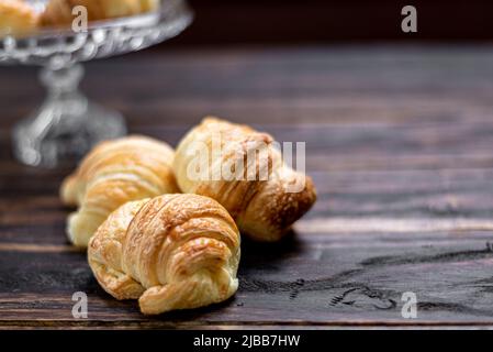 Croissants frais dans un bol en verre sur fond de bois Banque D'Images