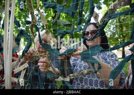 Lviv, Ukraine. 03rd juin 2022. Les femmes ont tissé un filet de camouflage pour l'armée ukrainienne lors de l'action 'aide - nous gagnons' dans les réfugiés de Lviv et les résidents de Lviv ont tenu une action 'aide - nous gagnons' du tissage de masse de filets de camouflage pour l'armée ukrainienne. Dans le parc, ils ont posé les bases pour tisser des filets de camouflage et les ont envés toute la journée. Crédit : SOPA Images Limited/Alamy Live News Banque D'Images