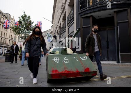 Londres, Royaume-Uni. 04th juin 2022. Les jeunes Hongkongers sont vus rouler le réservoir en carton à Regent Street. Un groupe de jeunes Hongkongais ont fabriqué un réservoir en carton et l'ont emportant à l'ambassade chinoise de Londres. Le 4th juin 1989, les troupes chinoises armées de fusils d'assaut et accompagnées de chars d'assaut ont tiré sur les manifestants étudiants et sur ceux qui essayaient de bloquer l'avancée de l'armée sur la place Tienanmen. À ce jour, le gouvernement chinois nie encore que l'incident s'est produit. Crédit : SOPA Images Limited/Alamy Live News Banque D'Images