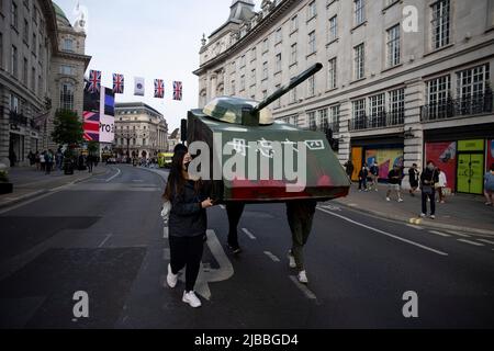 Londres, Royaume-Uni. 04th juin 2022. Les jeunes Hongkongers sont vus porter le réservoir en carton à Regent Street. Un groupe de jeunes Hongkongais ont fabriqué un réservoir en carton et l'ont emportant à l'ambassade chinoise de Londres. Le 4th juin 1989, les troupes chinoises armées de fusils d'assaut et accompagnées de chars d'assaut ont tiré sur les manifestants étudiants et sur ceux qui essayaient de bloquer l'avancée de l'armée sur la place Tienanmen. À ce jour, le gouvernement chinois nie encore que l'incident s'est produit. Crédit : SOPA Images Limited/Alamy Live News Banque D'Images