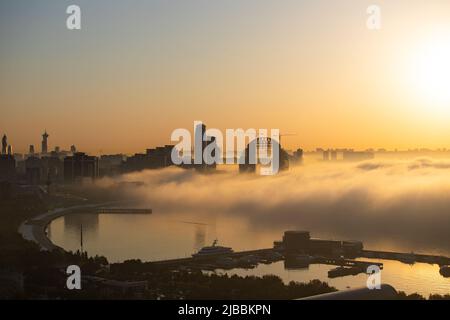 Un beau brouillard va au-dessus de l'eau et couvre la ville. Bakou. Azerbaïdjan. Banque D'Images