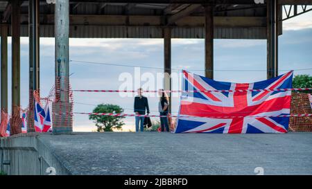 Drapeau de l'Union et rouleau de plastique qui se fend au coucher du soleil Banque D'Images