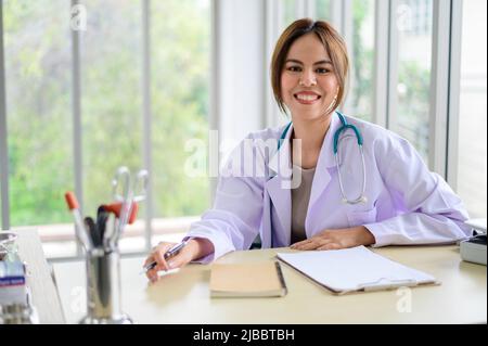 Belle jeune femme asiatique médecin assis à la réception Banque D'Images