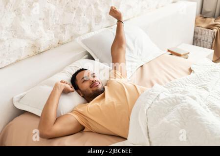 Welldord Moyen-Orient Homme Awakening bras étirant dans la chambre Banque D'Images