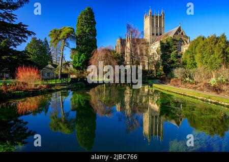 Cathédrale de Wells avec un reflet presque parfait sous le soleil d'hiver dans une piscine du Bishop's Palace, Somerset, Angleterre, Royaume-Uni Banque D'Images