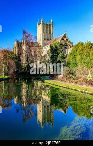 Cathédrale de Wells avec un reflet presque parfait sous le soleil d'hiver dans une piscine du Bishop's Palace, Somerset, Angleterre, Royaume-Uni Banque D'Images