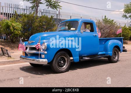 Un modèle 3100 1954 de Chevrolet restauré orné de 4 drapeaux américains. Partie d'une procession de voiture d'époque à la parade du jour du souvenir à College point. Banque D'Images