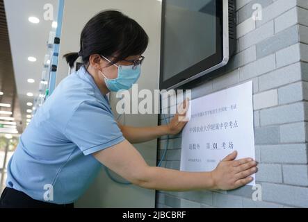 Pékin, Chine. 5th juin 2022. Un membre du personnel met un panneau à l'extérieur d'un site d'examen du prochain examen d'entrée au collège national pour 2022 à Pékin, capitale de la Chine, 5 juin 2022. Un nouveau haut de 11,93 millions d'étudiants passera l'examen d'entrée à l'université nationale de Chine en 2022, également connu sous le nom de « gaokao ». Crédit: REN Chao/Xinhua/Alay Live News Banque D'Images