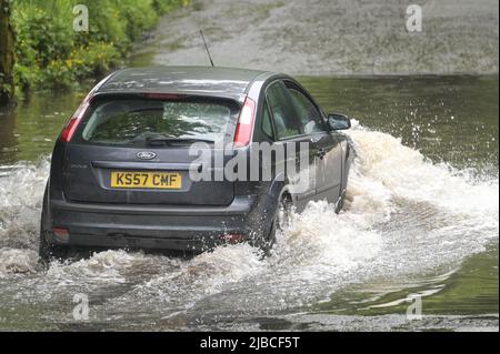 Hall Green, Birmingham, Angleterre, 5 juin 2022. Les conducteurs négocient une route inondée à Hall Green, Birmingham après une forte pluie pendant la nuit. Le temps humide a signifié que de nombreux grands déjeuners Platinum Jubilee ont été annulés dans la région. Crédit : arrêtez Press Media/Alamy Live News Banque D'Images