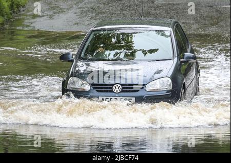 Hall Green, Birmingham, Angleterre, 5 juin 2022. Les conducteurs négocient une route inondée à Hall Green, Birmingham après une forte pluie pendant la nuit. Le temps humide a signifié que de nombreux grands déjeuners Platinum Jubilee ont été annulés dans la région. Credit : Stop Press MediaAlamy Live News Banque D'Images