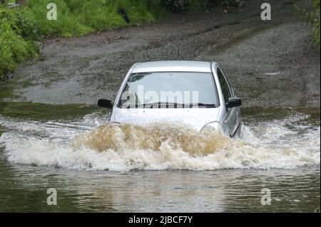 Hall Green, Birmingham, Angleterre, 5 juin 2022. Les conducteurs négocient une route inondée à Hall Green, Birmingham après une forte pluie pendant la nuit. Le temps humide a signifié que de nombreux grands déjeuners Platinum Jubilee ont été annulés dans la région. Credit : Stop Press MediaAlamy Live News Banque D'Images