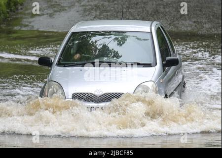 Hall Green, Birmingham, Angleterre, 5 juin 2022. Les conducteurs négocient une route inondée à Hall Green, Birmingham après une forte pluie pendant la nuit. Le temps humide a signifié que de nombreux grands déjeuners Platinum Jubilee ont été annulés dans la région. Credit : Stop Press MediaAlamy Live News Banque D'Images