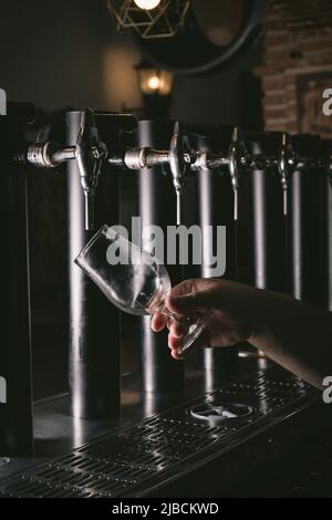 Main de bartender pouring une grande bière blonde au robinet. Banque D'Images