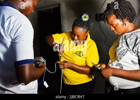 (220605) -- TIKO, 5 juin 2022 (Xinhua) -- Eposi Njoh Monyengi et son équipe installent un équipement électrique solaire dans une maison à Tiko, Cameroun, 24 mai 2022. POUR ALLER AVEC "Feature: Une femme camerounaise allume les communautés rurales avec l'énergie solaire" (photo de Keppeu/Xinhua) Banque D'Images