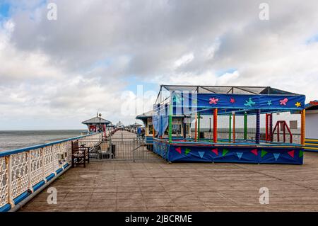 Les gens apprécient une promenade le long de la 2295 pieds de Grade ll classé victorien Llandudno Pier qui s'étend dans la mer d'Irlande qui a été achevée en 1878 Banque D'Images