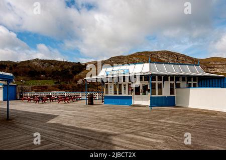 Un bar en bois peint en bleu et blanc orné avec des fenêtres et un grand toit avec des avant-toits suspendus sur la terrasse de l'embarcadère victorien classé Grade II Banque D'Images