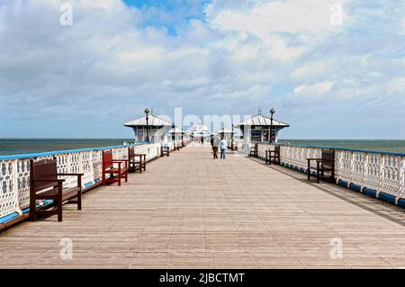 Les gens apprécient une promenade le long de la 2295 pieds de Grade ll classé victorien Llandudno Pier qui s'étend dans la mer d'Irlande qui a été achevée en 1878 Banque D'Images