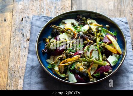 Salade chaude avec coléoptère rôti, brocoli, pomme, fenouil et câpres croustillantes Banque D'Images