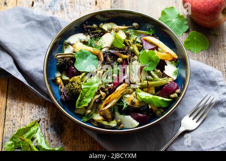 Salade chaude avec coléoptère rôti, brocoli, pomme, fenouil et câpres croustillantes Banque D'Images