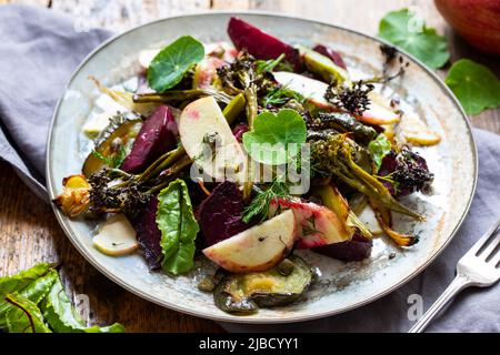 Salade chaude avec coléoptère rôti, brocoli, pomme, fenouil et câpres croustillantes Banque D'Images