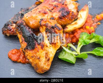 Ailes de poulet grillé avec pommes de terre, sauce piquante et salade de campagne Banque D'Images