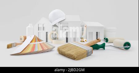 maison peintre outils, pinceaux, rouleaux de peinture, papier ruban de masquage et nuances de couleurs sur le bureau avec modèle de maison, fourniture et service dans la boutique de couleurs dans le Banque D'Images