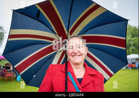 Willingham Cambridgeshire, Royaume-Uni. 5th juin 2022. Les gens célèbrent le week-end du Jubilé de platine de la Reine sous la pluie lors d'un pique-nique sur le terrain de loisirs. Beaucoup de gens étaient déterminés à célébrer l'occasion malgré la pluie torride, en apportant leurs propres pique-niques et en appréciant un groupe de blues, des stands de nourriture, un bar et des jeux. Crédit : Julian Eales/Alay Live News Banque D'Images