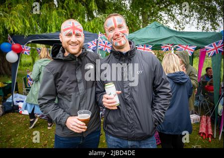 Willingham Cambridgeshire, Royaume-Uni. 5th juin 2022. Les gens célèbrent le week-end du Jubilé de platine de la Reine sous la pluie lors d'un pique-nique sur le terrain de loisirs. Beaucoup de gens étaient déterminés à célébrer l'occasion malgré la pluie torride, en apportant leurs propres pique-niques et en appréciant un groupe de blues, des stands de nourriture, un bar et des jeux. Crédit : Julian Eales/Alay Live News Banque D'Images