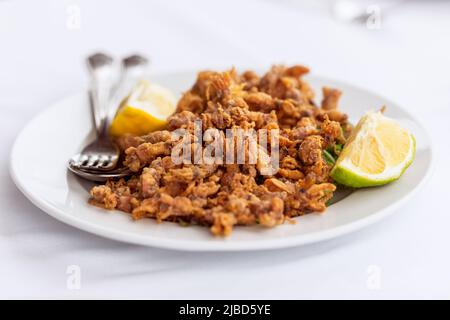 En-cas méditerranéen traditionnel Moscardini petite seiche frite (poulpe) avec une tranche de citron Banque D'Images