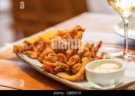 Mélange de fruits de mer frits avec crevettes, calmar et poulpe et sauce mayonnaise (fritto misto di mare), apéritif typiquement italien Banque D'Images