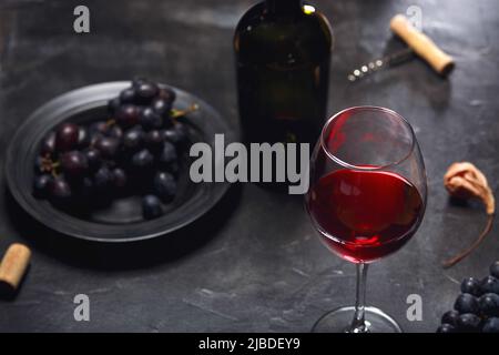 vin rouge et raisins. Vin et raisins dans un cadre vintage avec des bouchons sur une table en bois. Vue de dessus Banque D'Images