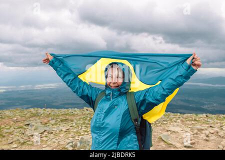 Randonneur 50s femme avec drapeau de l'Ukraine sur le sommet de la montagne de Babia Góra, le Près de liberté, de victoire, de mode de vie actif Banque D'Images