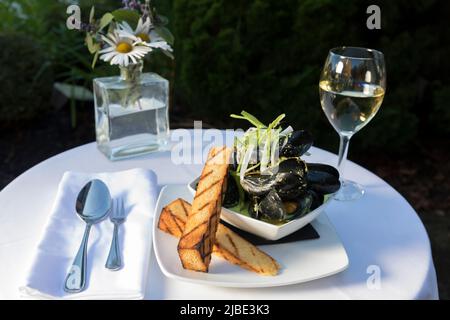 Un plat de moules avec vin dans un cadre extérieur Banque D'Images