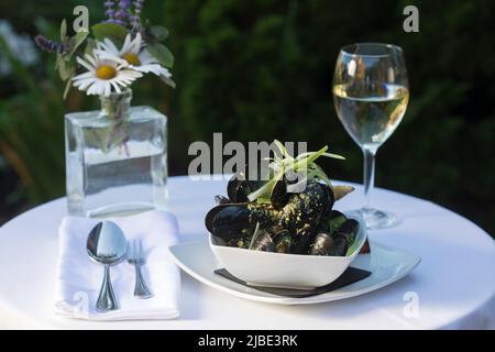 Un plat de moules avec vin dans un cadre extérieur Banque D'Images