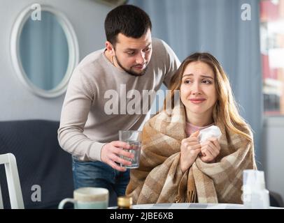 Femme malade qui se repose à la maison avec son mari Banque D'Images