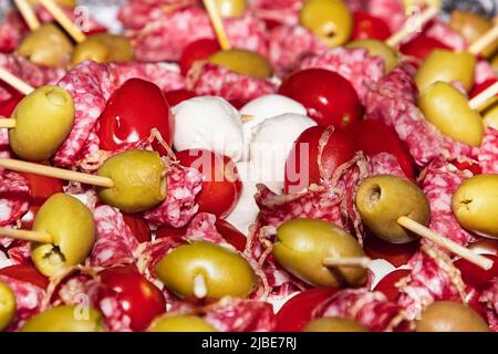 hors-d'œuvre avec saucisse, olives et mozzarella sur brochettes. Buffet avec canapés et hors-d'œuvre sur brochettes en bois. Saucisse, olives, mozzarella se Banque D'Images