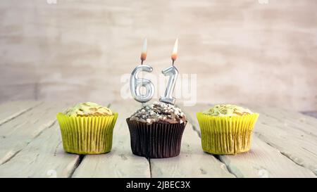 Joyeux anniversaire muffins avec des bougies avec le numéro. Espace de copie de carte avec chaussons pour Félicitations. Banque D'Images