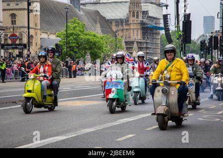 Londres, Royaume-Uni. 5th juin 2022. Les mods passent sur leurs scooters pour représenter la scène 1950s dans le cadre du Jubilé de platine qui se tient dans le centre de Londres pour marquer les 70 ans de sa Majesté sur le trône. La parade de 3km est dirigée par l'entraîneur d'État d'or, une voiture de 260 ans qui transportait la Reine vers et depuis son couronnement en 1953. Credit: Kiki Streitberger / Alamy Live News Banque D'Images