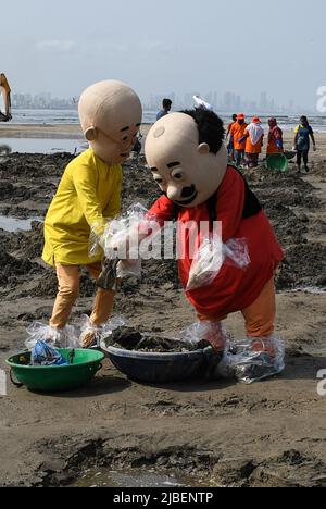 Mumbai, Inde. 05th juin 2022. NickToons Motu (R) et Patlu (L) (gras et mince) mettent les déchets collectés dans un seau de transport des déchets. Le nettoyage de la plage a été effectué à la plage de Versova à l'occasion de la Journée mondiale de l'environnement pour attirer les amateurs de plage à utiliser des poubelles pour jeter des couvercles en plastique, des bouteilles et d'autres déchets. (Photo par Ashish Vaishnav/SOPA Images/Sipa USA) crédit: SIPA USA/Alay Live News Banque D'Images