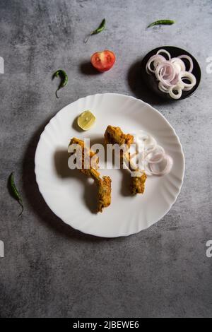 Vue de dessus des morceaux de poulet frits dans une assiette blanche sur un fond. Mise au point sélective. Banque D'Images