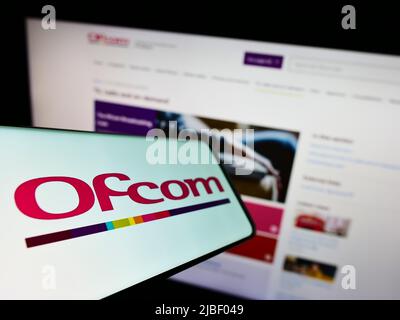 Smartphone avec le logo de l'Office of Communications (Ofcom) de l'autorité britannique à l'écran, devant le site Web. Mise au point au centre-gauche de l'écran du téléphone. Banque D'Images