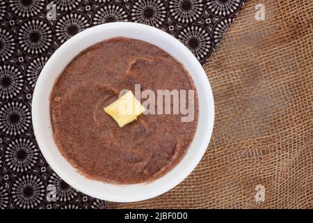 Petit déjeuner traditionnel africain au sorgho porridge ou Mabele, sur gris marbré avec espace de copie Banque D'Images