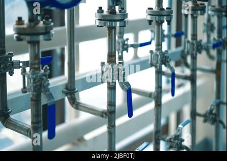 Canalisations minces avec leviers bleus ouverts et fermés à l'usine Banque D'Images