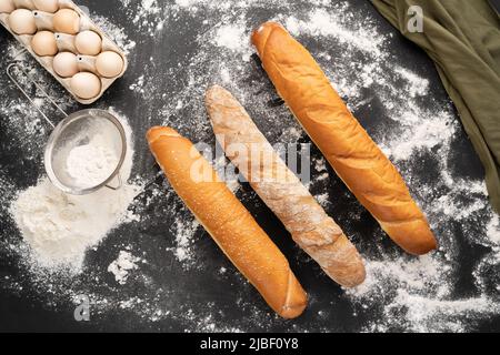 regardez la photo d'une variété de baguette française sur un fond de tableau noir oeufs tamis et farine. La vie fixe est capturée à partir de la bannière ci-dessus. Banque D'Images