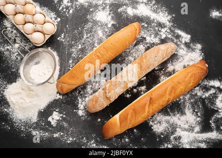 regardez la photo d'une variété de baguette française sur un fond de tableau noir oeufs tamis et farine. La vie fixe est capturée à partir de la bannière ci-dessus. Banque D'Images