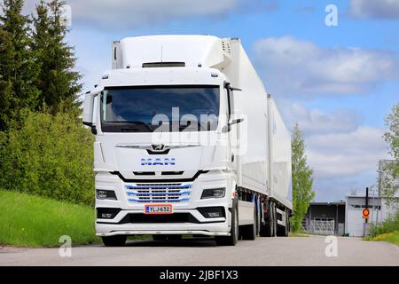 Camion noir neuf MAN TGX 26,510 devant une remorque réfrigérée stationnée sur une cour d'asphalte. Salo, Finlande. 29 mai 2022. Banque D'Images