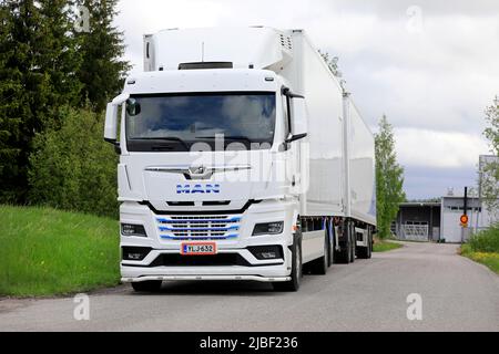 Camion noir neuf MAN TGX 26,510 devant une remorque réfrigérée stationnée sur une cour d'asphalte. Salo, Finlande. 29 mai 2022. Banque D'Images