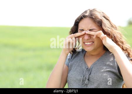 Femme stressée se grattant les yeux dans un champ de blé Banque D'Images