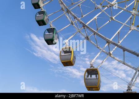 Gros plan de la roue de Ferris de Tempozan multicolore dans un parc d'attractions avec ciel bleu à Tbilissi, Géorgie Banque D'Images