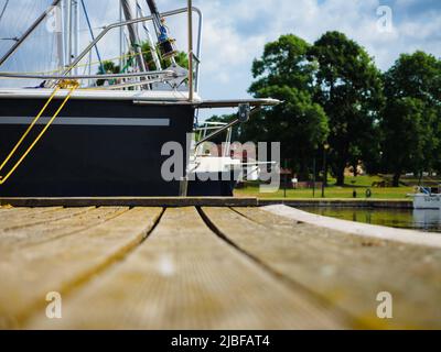 vue sur un voilier amarré sur une jetée en bois dans le port, vue rapprochée sur la coque et l'arc du voilier Banque D'Images